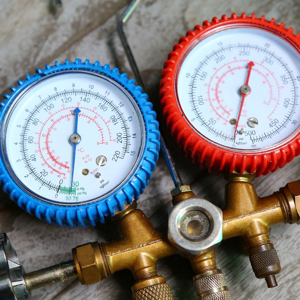 Refrigeration engineer checking pressure with a pressure gauge